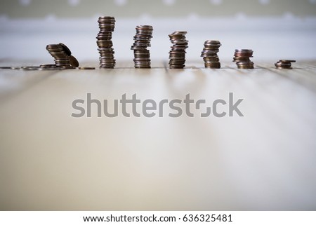 Accumulated coins stacked in piles on the wooden floor
