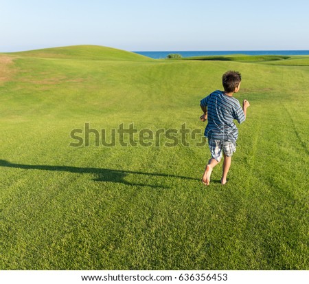Child running on the grass field