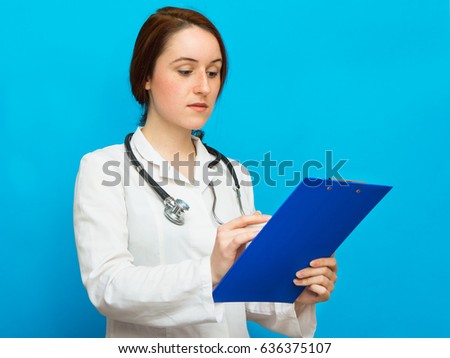 Young beautiful female doctor showing blank area for sign or copyspace, blue background