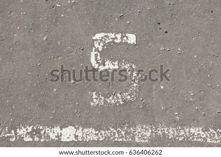 Number 5, five, painted on asphalt, running track