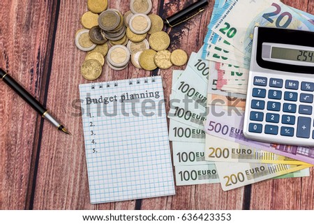 Budget planning word In notepad with euros, calculator, coin and pen.