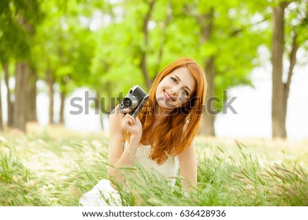 portrait of beautiful young woman with retro camera on the wonderful park background