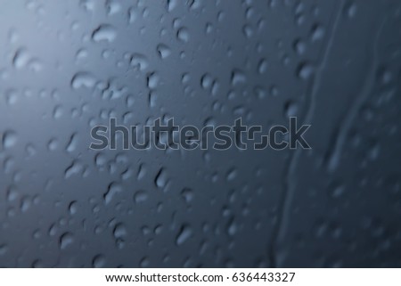 Raindrops on the fogged glass (dark blue tint with light spot) (bokeh)