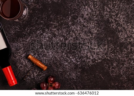 Wine, glasses, grapes and corkscrew over stone background. Top view with copy space.