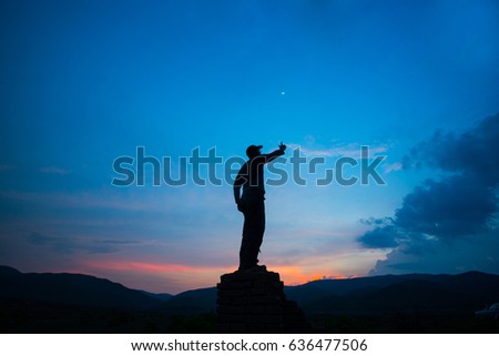 man hope try to reach the moon at blue sky background 