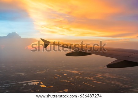 Sunset in twilight time with Wing of an airplane and cloud sky. Photo applied to tourism operators. picture for add text message or frame website. Traveling concept