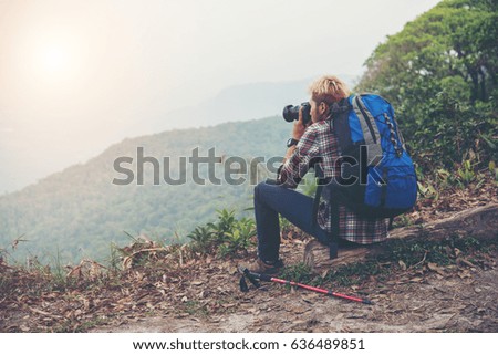 Rare of young traveller man with backpack standing in mountain and taking a photo. Male hiker photographing a beautiful mountain landscape.