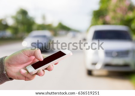 Man use cell phones for help because his car has problems on the road.