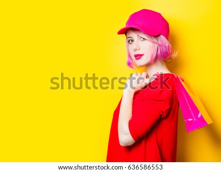 portrait of beautiful smiling young woman with shopping bag on the wonderful yellow studio background