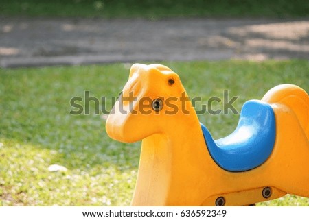 horse toy on blurred nature green grass in outdoor playground - Concept background 