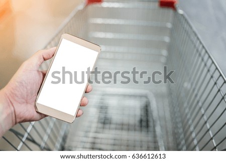 hand use smartphone with blur background of supermarket