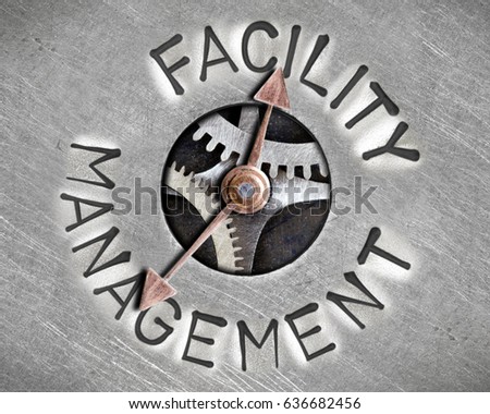 Macro photo of pointer and tooth wheel mechanism with FACILITY MANAGEMENT letters imprinted on metal surface