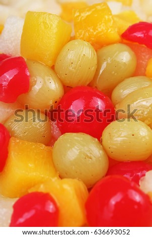 
Fruit salad texture. Fruits as background pattern. Exotic Fruits  Fruit salad with cocktail cherry sour cherry mango pineapple grapes,pear,maracuja,papaya in syrup.
