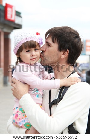 Dad kisses little daughter on the cheek 