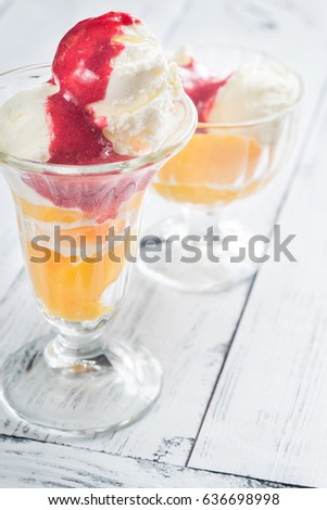 Two bowls of Peach Melba - vanilla ice cream with peaches and raspberry sauce