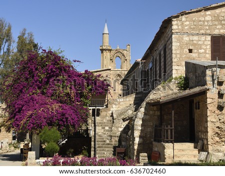 Old house in a church area with a blossom bouganvillea and a blue sky in background, picture from the Northern Cyprus.