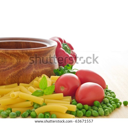 Uncooked pasta with fresh green peas, tomatoes, and basil - isolated on white background