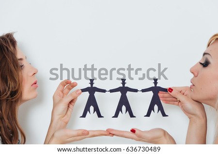 Close-up of women hands holding paper people over body background isolated on white background. People, population, friendship concept.