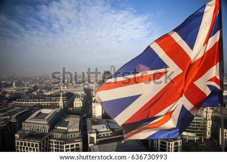  British Union Jack flag and aerial view of London with financial symbols of London in the background - Brexit concept