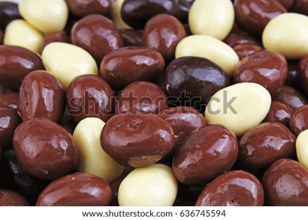 Dark and dairy chocolate balls.  Chocolate drops as background texture pattern. Bon bons. Choco eggs. Chocolate covered raisin. Raisins with chocolate.