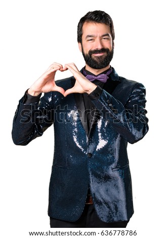 Handsome man with sequin jacket making a heart with his hands