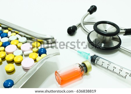 Stethoscope, Vial of Drug and 3 ml Plastic Syringe with Needle and Drug Tablets on the Medication Tray  Isolated on the White Background