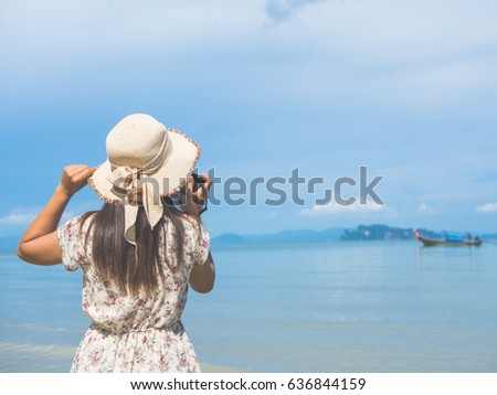 Close up Portrait of beautiful woman with retro hipster camera having fun at the beach.