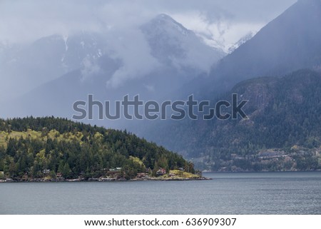 Bowyer Island with the North Shore Mountains in the Background. Picture taken in Howe Sound near Vancouver, British Columbia, Canada, during a gloomy rainy day.