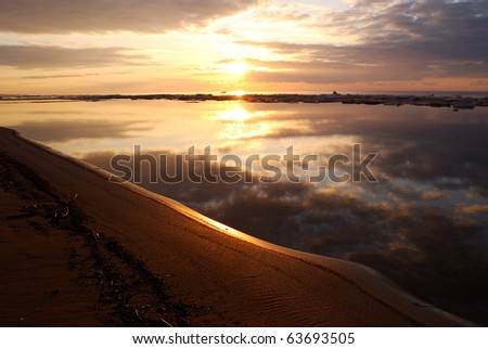 sunset at the sea shore reflecting in spring