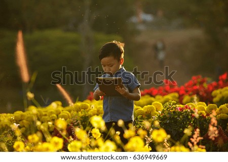 Man photo with flowers,boy in the garden with my tablet.