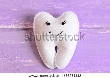Felt tooth fairy toy isolated on wooden background. Adorable felt tooth fairy for little kids. Homemade children's stuffed toy idea. Top view. Closeup