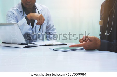 Medicine doctors working with computer notebook and digital tablet  at desk in the hospital. Medical teamwork discussion