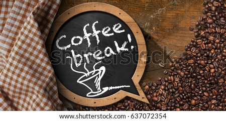Coffee Break - Blackboard in the shape of a speech bubble with roasted coffee beans and a coffee cup. On a wood background with a checkered tablecloth