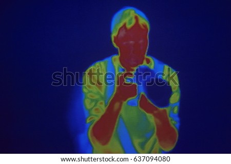 Thermographic image of the photographer. Photo showing different temperatures in range of colors, blue showing cold, red showing hot which can indicate joint inflammation