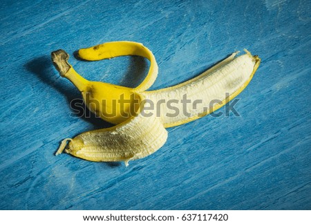 Peeled banana on a blue wooden background