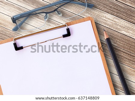 Medical clipboard and glasses with pencil on wooden table background. Health concept