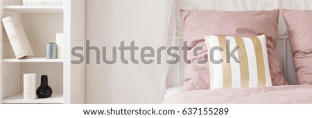 Stylish white and pink bedroom with shelf and bed