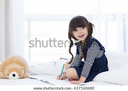 Asian love family happy, beautiful girl happy to write a book on the bed.