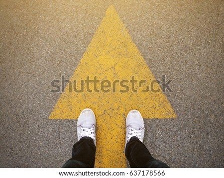 Feet and arrows on road. Royalty-Free Stock Photo #637178566