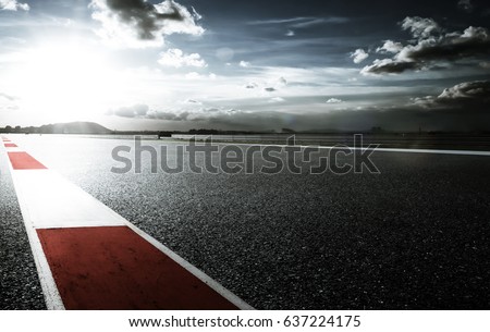 Racetrack with red and white safety sideline ,dramatic cloudy sky and cold mood filter apply . Royalty-Free Stock Photo #637224175