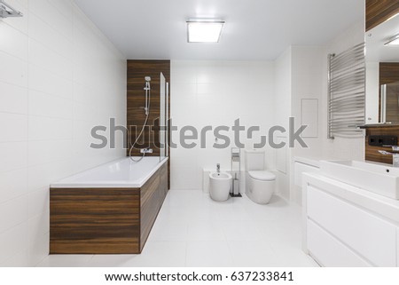 Master bathroom in a luxury apartment downtown. Brand new white ceramic sanitary wear. Wooden elements. Classic with loft elements.  Royalty-Free Stock Photo #637233841