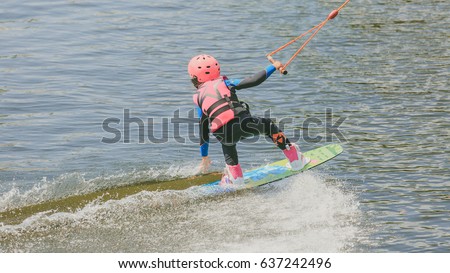 a little girl to ride a Wakeboard. Kitesurfing. Photo of grain processing