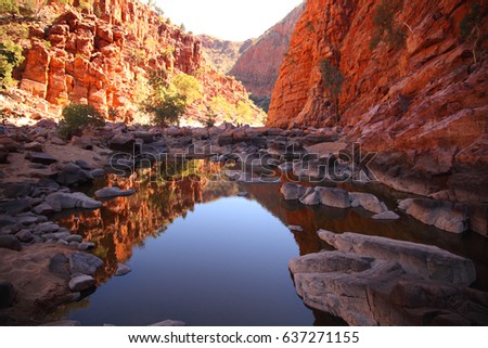 Ormiston Gorge in the West MacDonnell Range reflected in a pool of water. Royalty-Free Stock Photo #637271155