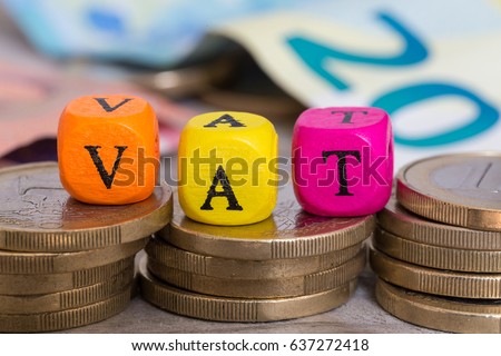 VAT letter cubes on coins concept. Royalty-Free Stock Photo #637272418
