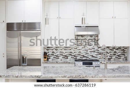 Snapshot of interior modern kitchen with granite countertop island and smart refrigerator Royalty-Free Stock Photo #637286119