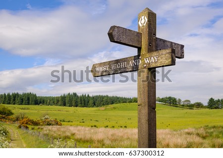 West Highland Way, Scotland - A wooden sign post with sign and icon of West Highland Way. Wooden pole with directional sign post for the West Highland Way in Scotland. Royalty-Free Stock Photo #637300312