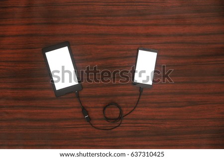 Data transfer concept. Tablet and phone connected with USB cable. Flat lay.