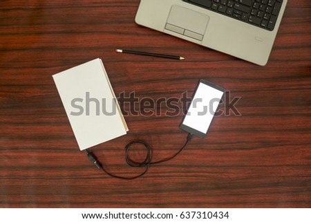 Data transfer concept. Cellphone and book connected with USB cable. Flat lay.