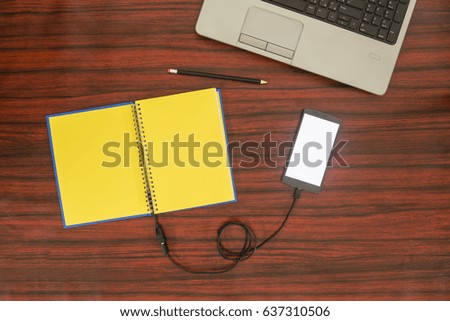 Data transfer concept. Cellphone and book connected with USB cable. Flat lay.