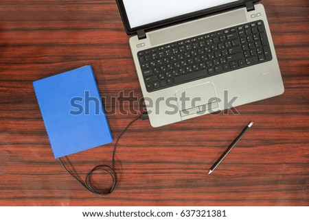 Data transfer concept. Book and a laptop connected with USB cable.